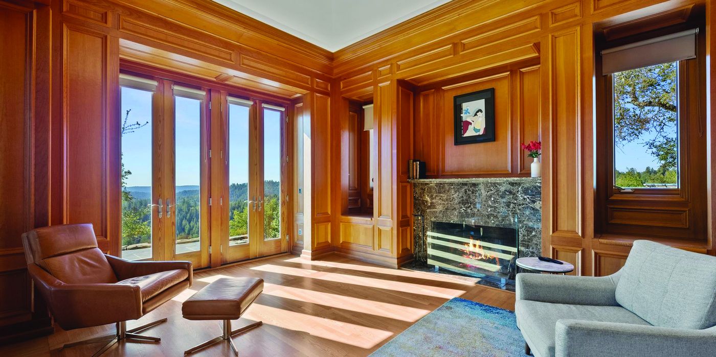 Wood-paneled living room with fireplace and wide windows overlooking the mountains at 15220 Upper Ellen Road