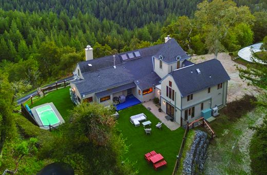 Aerial view of the property with pool, surrounded by forest